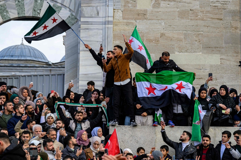Syrian residents in Turkey celebrate at the Fatih Mosque, in Istanbul. — AFP pic