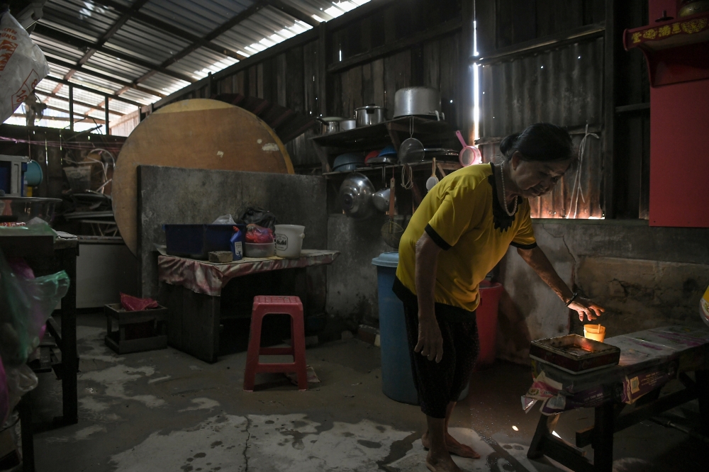 A flood victim inspects items damaged by floods after returning home in Alor Setar, on Dec 8, 2024. — Bernama pic
