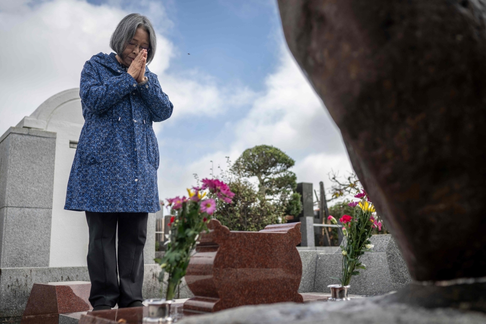 This picture taken on November 27, 2024 shows Michiko Murata, who helps run the Tokyo Federation of A-Bomb Sufferers Organizations, which calls itself ‘Toyukai’, praying at the tomb for Japanese atomic bombing survivors in Hachioji city, Tokyo prefecture. — AFP pic 