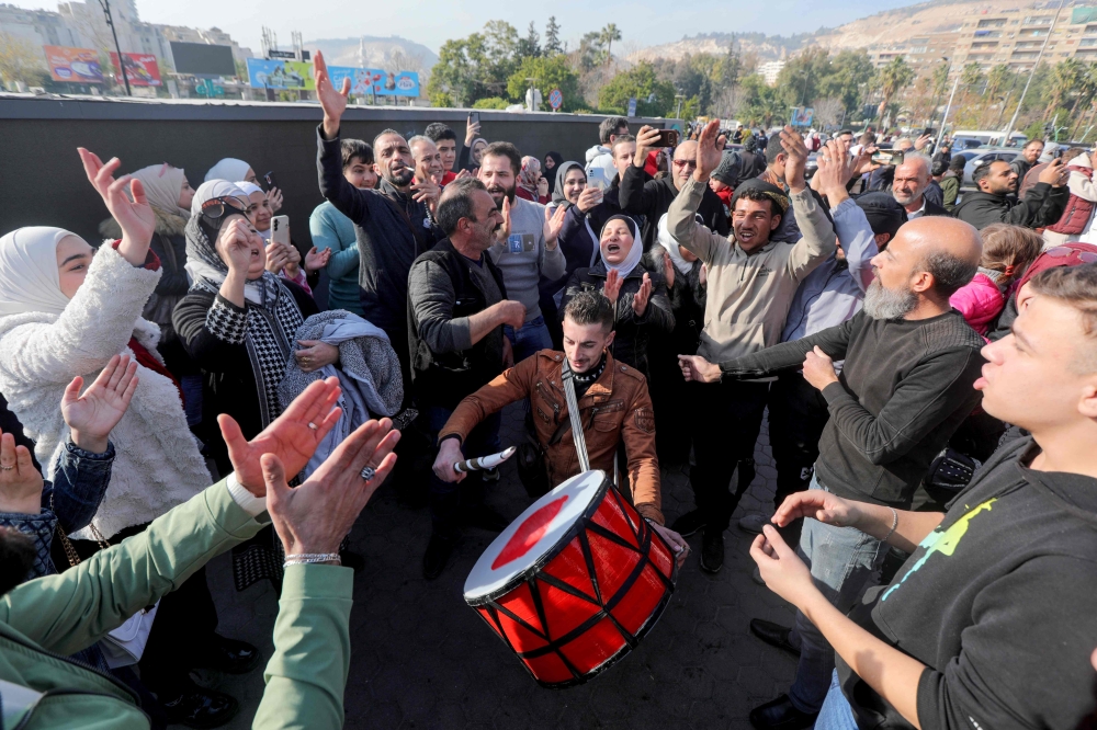 People in Damascus celebrate on December 9 after Islamist-led rebels declared that they have taken the Syrian capital in a lightning offensive, sending President Bashar al-Assad fleeing and ending five decades of Baath rule in Syria. — AFP