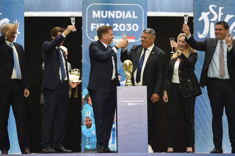 Conmebol President Paraguayan Alejandro Dominguez (3rd left) toasts with the President of the Argentine Football Association (AFA), Claudio Tapia, as they celebrate the ratification of Argentina, Paraguay and Uruguay as host countries of the Fifa 2030 World Cup during the Fifa virtual Congress in Luque, Paraguay, on December 11, 2024. A virtual Congress of world football's governing body confirmed that Morocco, Spain and Portugal will be joint hosts of the 2030 World Cup, which will also see three games played in South America. — AFP pic