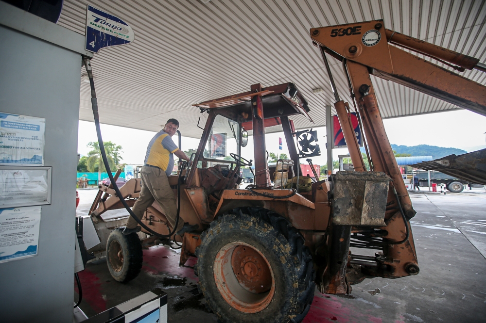 A person fills an excavator with diesel at a fuel station in Khantan, Perak  on June 10,2024. — Picture by Farhan Najib