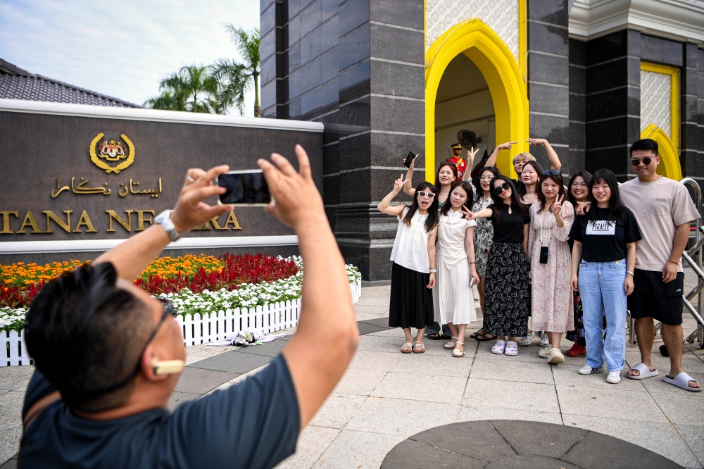 Tourists from China pose for a photo at the main gates of Istana Negara in Kuala Lumpur July 20, 2024, during the Installation Ceremony of Sultan Ibrahim as the 17th King of Malaysia. — Bernama pic