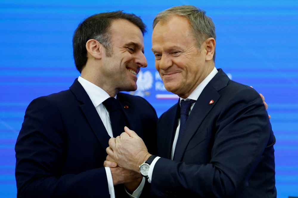 Polish Prime Minister Donald Tusk shakes hands with French President Emmanuel Macron, at the Chancellery of the Prime Minister, in Warsaw, Poland, December 12, 2024. — Reuters pic  