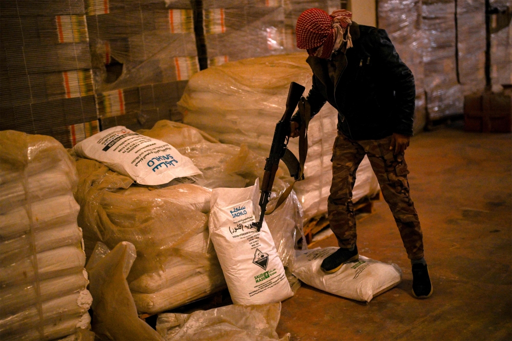 Syrian rebel fighters inspect sacks marked to contain 