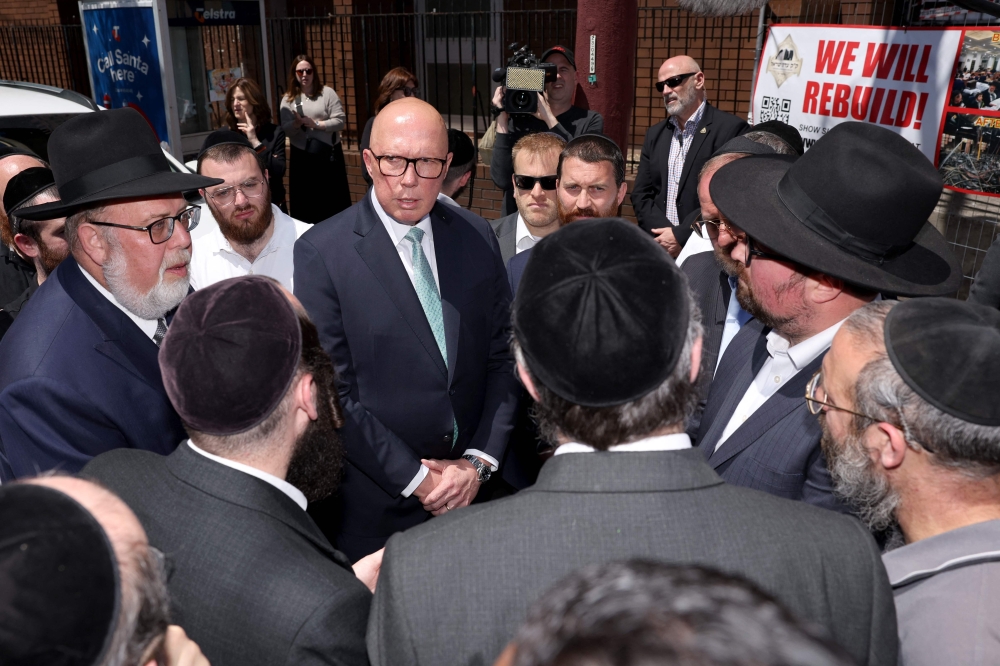 Australia's opposition leader Peter Dutton (centre) speaks to members of the Jewish community outside the damaged Adass Israel Synagogue in the Melbourne suburb of Ripponlea on December 9, 2024. Dutton said his proposal — which would require overturning Australia’s 26-year nuclear ban — would lead to comparatively lower costs and a more reliable electricity supply. — AFP pic