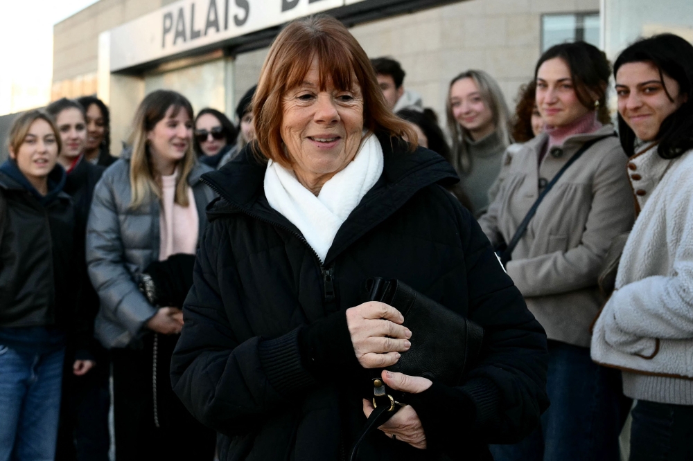 Gisele Pelicot (centre) reacts in front of young supporters, gathered at the Avignon courthouse, during the trial of her former partner Dominique Pelicot accused of drugging her for nearly ten years and inviting strangers to rape her at their home in Mazan, a small town in the south of France, in Avignon, on December 10, 2024. 