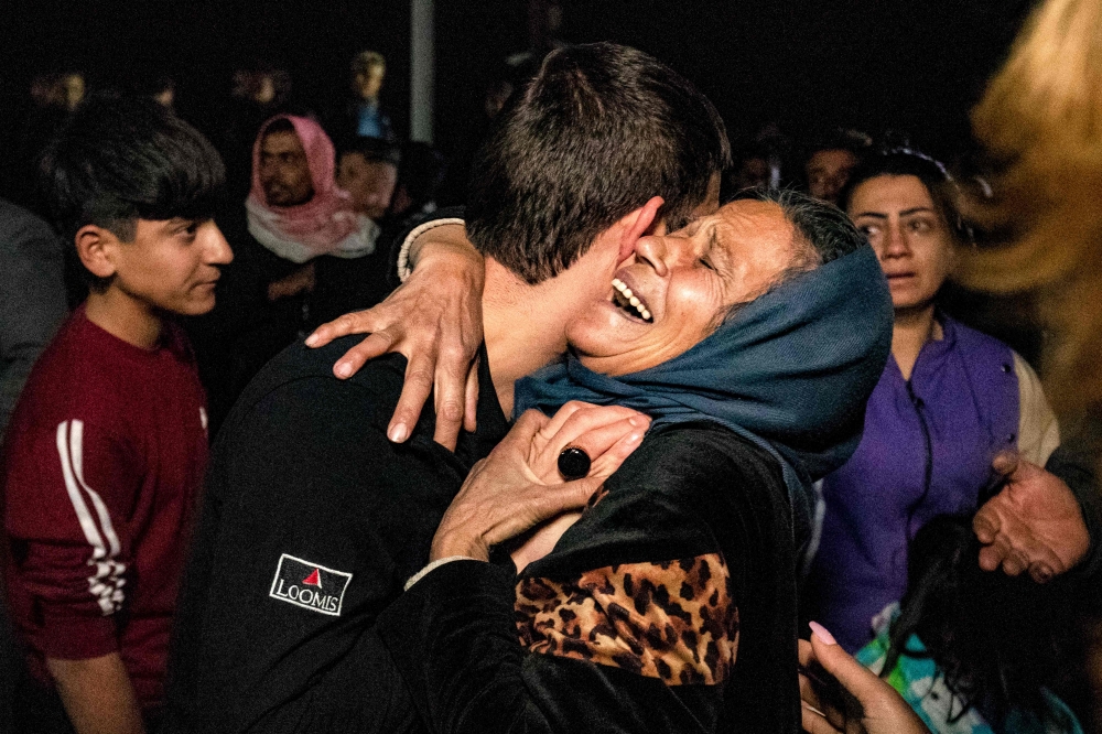 A woman reacts while she embraces a man as relatives greet former prisoners released by the Syrian Kurdish administration after a general amnesty was issued, in Qamishli in northeastern Syria on December 12, 2024. — AFP pic