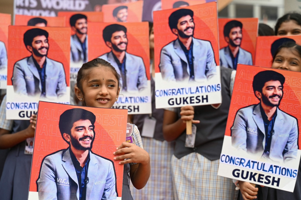Indian school students congratulate the world's youngest chess champion Gukesh Dommaraju, in Chennai on December 13, 2024.  — AFP pic