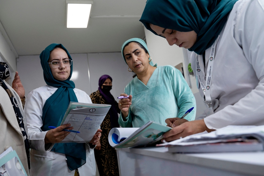 Female midwives and nurses check the documents of pregnant women at a private hospital in Kabul, Afghanistan, on Dec 10, 2024. — AFP pic