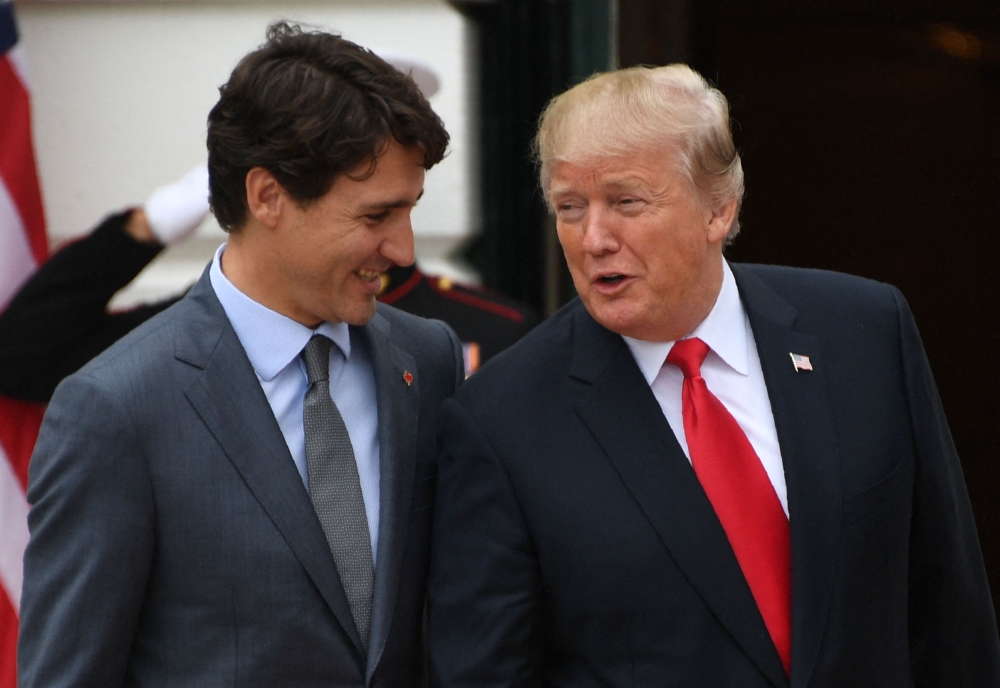 US President Donald Trump (right) welcomes Canadian Prime Minister Justin Trudeau at the White House in Washington, DC, on October 11, 2017. The political circumstances that surrounded the publication of ‘Ultimatum,’ once a best-selling novel that imagined an American effort to annex Canada, may ring familiar to anyone following recent headlines. — AFP pic