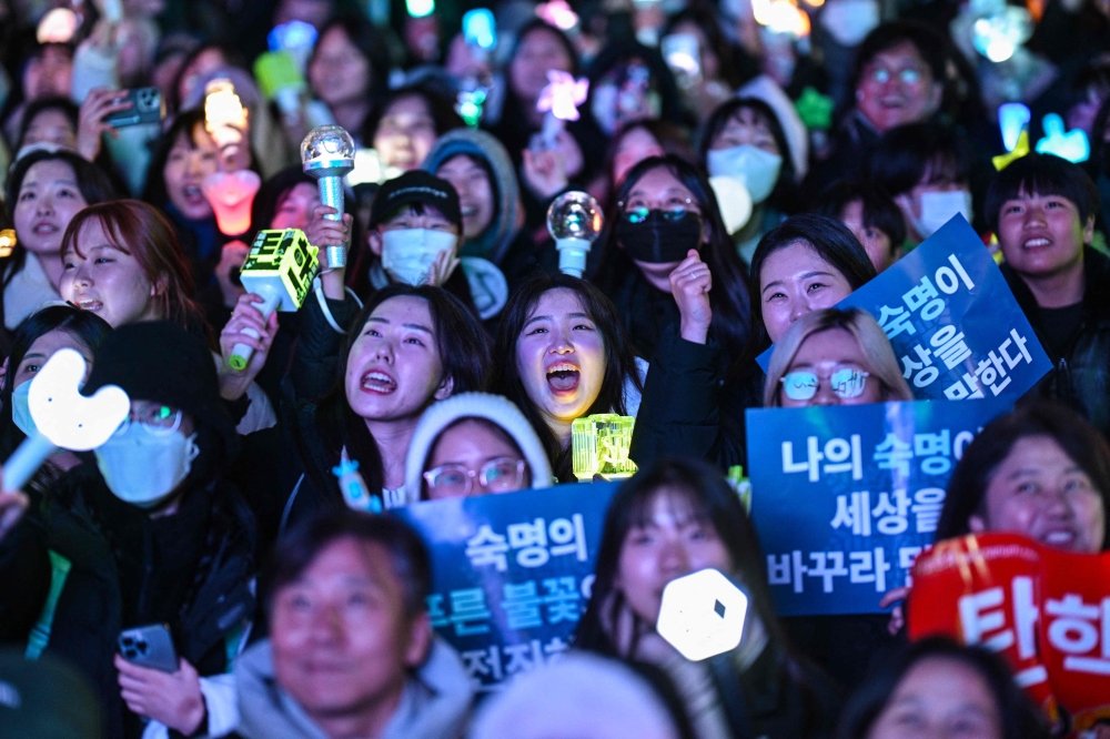 Protesters calling for the ouster of South Korea President Yoon Suk Yeol react after the result of the second martial law impeachment vote outside the National Assembly in Seoul on December 14, 2024. — AFP pic