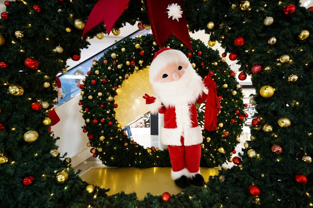 A person dressed as Santa Claus poses to camera during Christmas season at a shopping mall in Jakarta December 14, 2024. — Reuters pic
