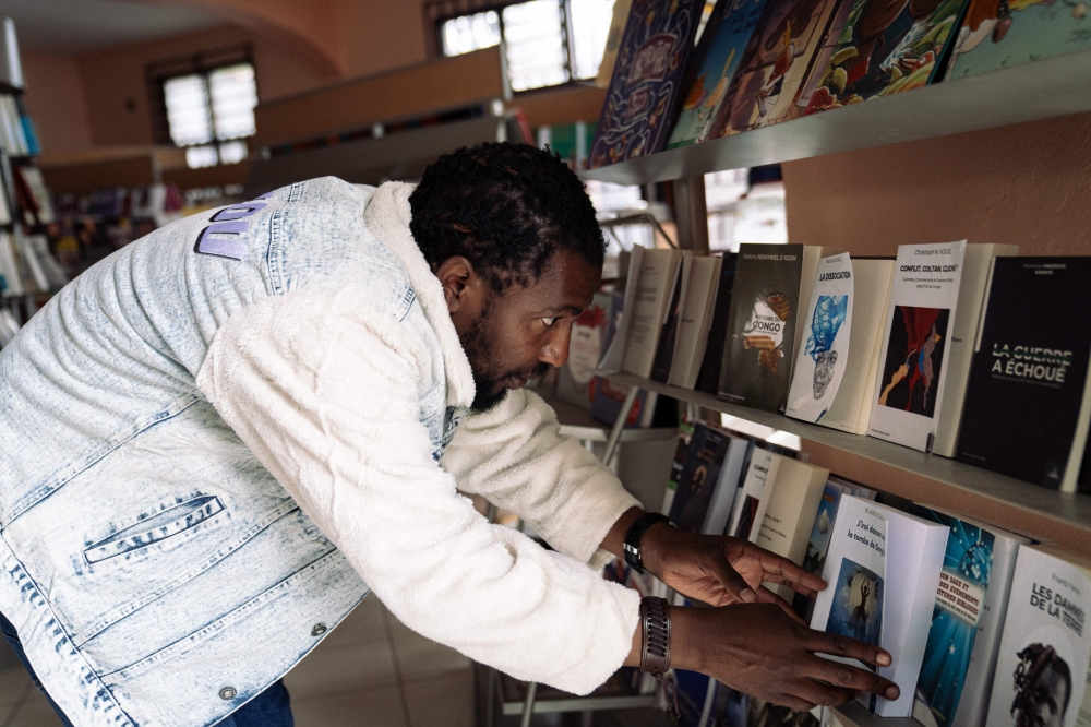 Co-founder of Mlimani Editions Depaul Bakulu looks at books on sale at the ‘Lave Litteraire’ bookshop in Goma, in the east of the Democratic Republic of Congo November 22, 2024. In the DR Congo, access to reading is very complicated, not least because of the price of books and access to African authors who can resonate with local populations. With this in mind, Mlimani is working to re-edit books by Congolese or African authors and print them in Goma, where they can then be offered at prices suited to the population's standard of living. — AFP pic