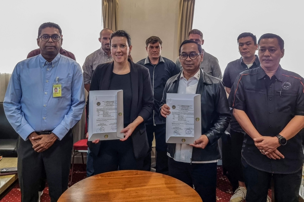 Director of Prisoner Development of the Directorate General of Corrections of the Republic of Indonesia Erwedi Supriyatno (second right) and Australian Representative, Minister-Counsellor Home Affairs, Regional Director South-East Asia, Lauren Richardson (second left) holding the signed transfer of 'Bali Nine' prisoners. — AFP pic