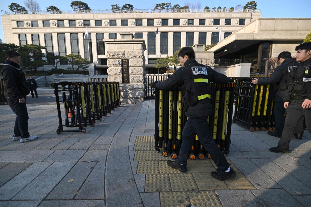 Policemen set up barricades in front of the Constitutional Court in Seoul on December 16, 2024, as the court is set to hold its first meeting of its justices to review the parliamentary impeachment of President Yoon Suk Yeol. — AFP pic