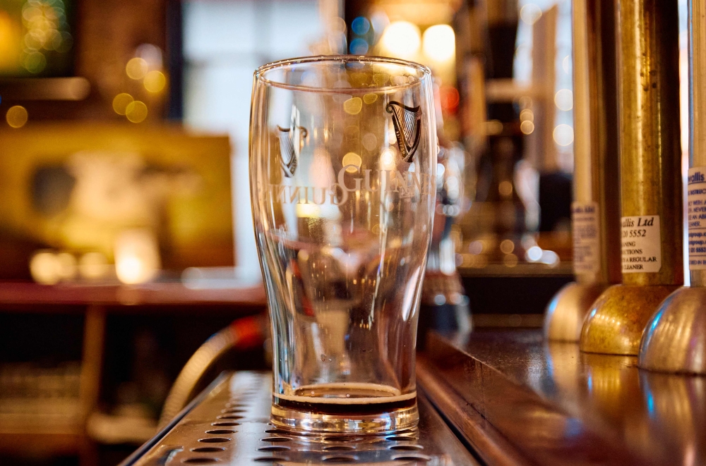An empty Guinness glass, seen behind the bar inside The Old Ivy House public house in Clerkenwell, London December 15, 2024. — AFP pic