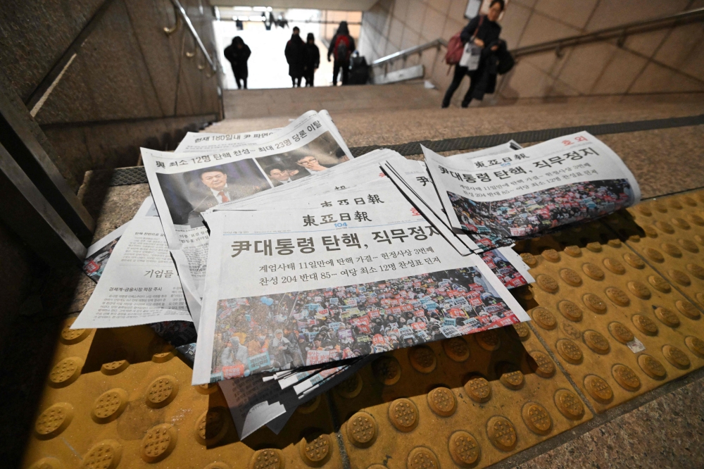 Extra edition newspapers are displayed at a subway station gate in downtown Seoul on December 14, 2024, after the impeachment motion against South Korean President Yoon Suk Yeol was passed. — AFP pic