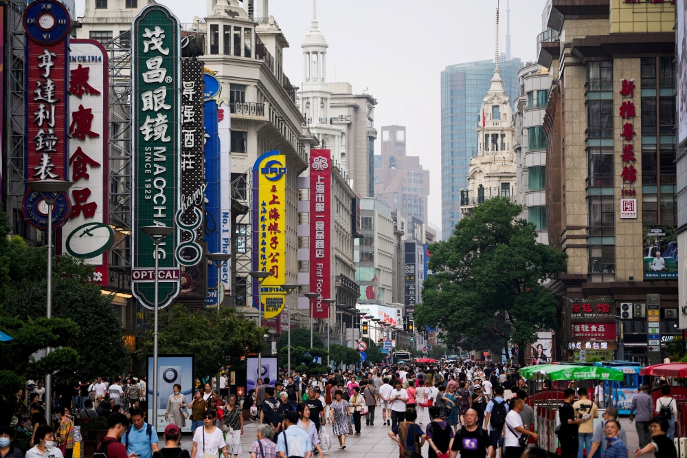 People walk along Nanjing Pedestrian Road, a main shopping area, ahead of the National Day holiday, in Shanghai, China September 26, 2023. Chinese leaders agreed last week to raise the budget deficit to 4 per cent of gross domestic product (GDP) next year, its highest on record, while maintaining an economic growth target of around 5 per cent, two sources with knowledge of the matter said. — Reuters pic 
