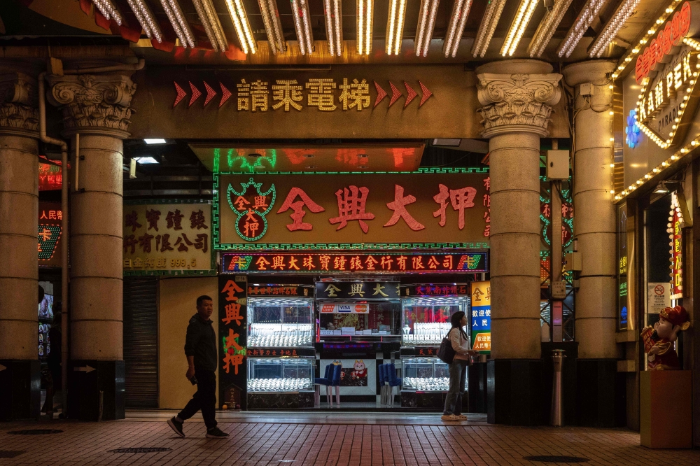 This photo taken on December 12, 2024 shows a visitor walking by a pawnshop next to Casino Lisboa in Macau. As Macau this week celebrates 25 years under Beijing rule, many feel more urgently than ever that the city needs to diversify its economy — which Beijing had demanded for years to underwhelming results. — AFP pic 