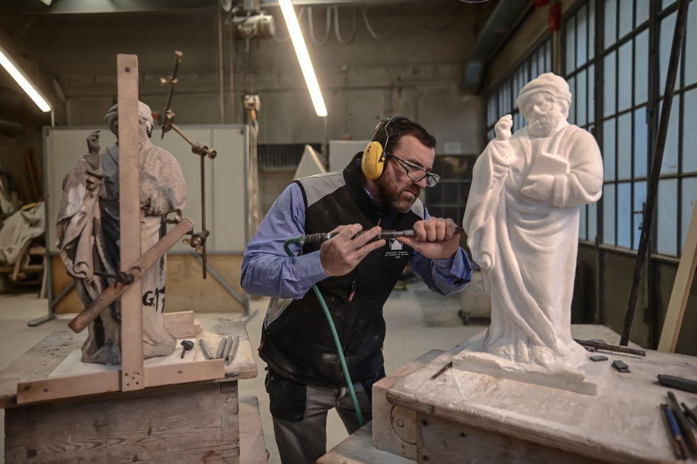 Sculptor Giovanni Calderino, 46, carves a Candoglia marble statue with a pneumatic hammer at Cantiere Marmisti, the marble yard where marble from the Candoglia quarry is turned into ashlars, architectural and ornamental elements, sculptures and statues of Milan’s Duomo Cathedral, on December 11, 2024 in Milan. — AFP pic 