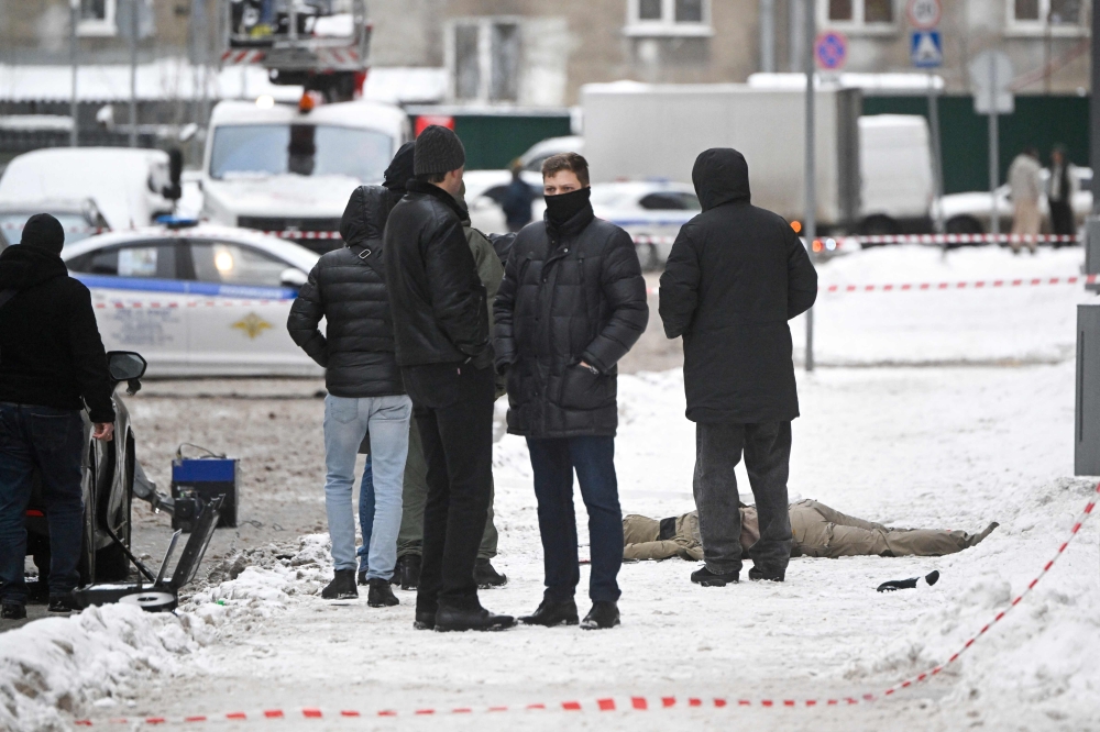 Investigators gather by a body at the blast scene, which killed the commander of Russian armed forces’ chemical, biological and radiation defence troops, Igor Kirillov, and his assistant, according to the Russian Investigative Committee, outside a residential building on Ryazansky Avenue in Moscow on December 17, 2024. — AFP pic 