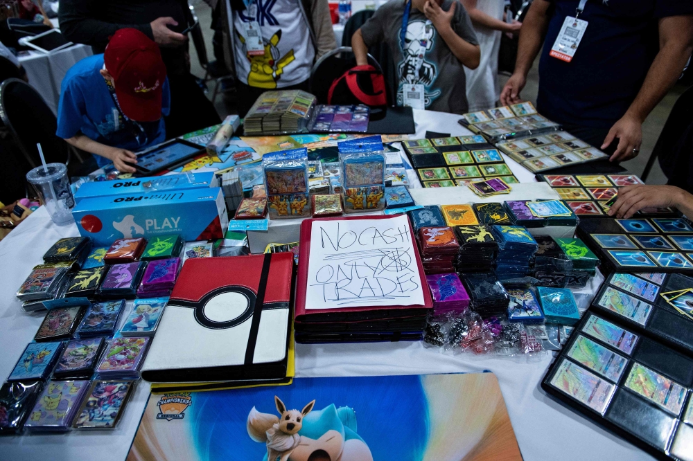 People trade Pokemon cards during the first day of the 2019 Pokemon World Championships at the Washington Convention Center in this file picture dated August 16, 2019, in Washington, DC. With more than 60 million downloads and nearly US$180 million generated worldwide since the end of October 2024, the mobile game adaptation of Pokemon cards has enjoyed global success, not far from the records of its predecessor. — AFP pic 