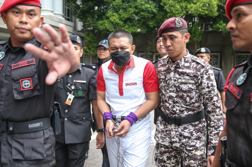 Former police commando Azilah Hadri is escorted out after his death sentence was commuted at the Federal Court in Putrajaya on October 10, 2024. — Picture by Yusof Mat Isa