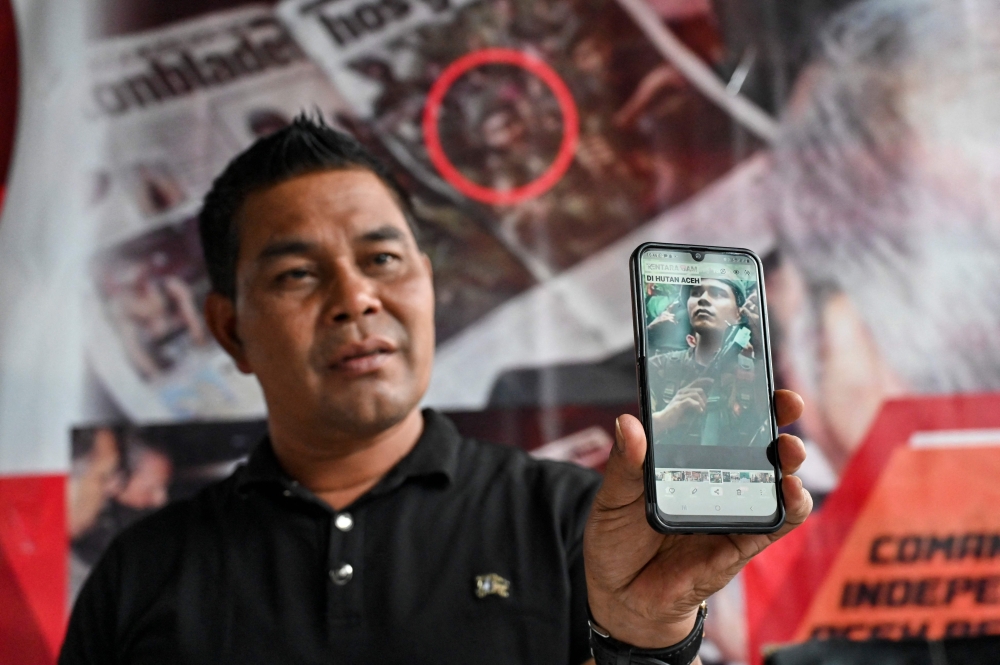 In this photo taken on November 22, 2024, Muharram Idris, a former commander of the Free Aceh Movement (GAM), shows a photo of himself in Pekan Bada near Banda Aceh, Indonesia’s Aceh province. Former rebel commander Muharram Idris once led 3,000 men to fight Indonesia’s army in separatist Aceh, but now serves as a local official after the legacy of a devastating tsunami two decades ago brought peace to the province. — AFP pic 