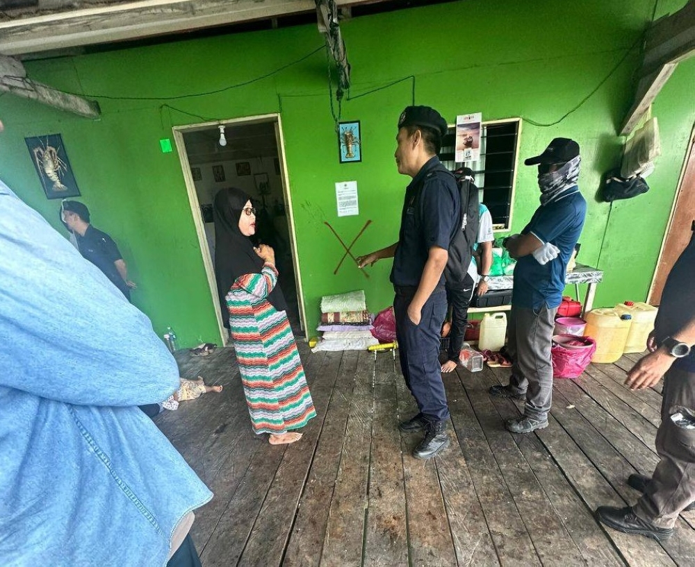 Sitti Bandorah, the widow of Sergeant Abd Azis Sarikon, who was killed during the intrusion by self-styled Sulu militants in early 2013, speaks to officers during the enforcement operation in Pulau Bodgaya, Semporna, yesterday. — Picture via Facebook