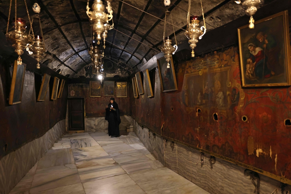 A Christian worshipper visits the Church of the Nativity in the biblical city of Bethlehem, in the occupied West Bank December 17, 2024. On Bethlehem's Manger Square, Christmas decorations and pilgrims are notably absent for a second wartime festive season in the Israeli-occupied West Bank city. — AFP pic