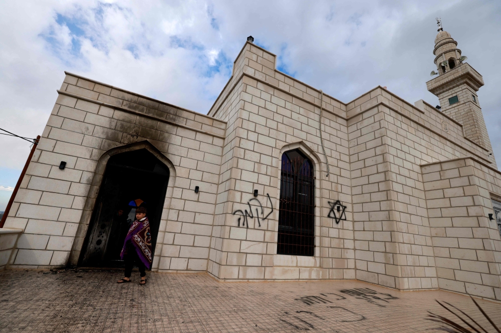 Palestinians inspect the damage done to a mosque, after a reported attack by Israeli settlers, in the town of Marda near the West Bank city of Salfit on December 20, 2024. — AFP pic