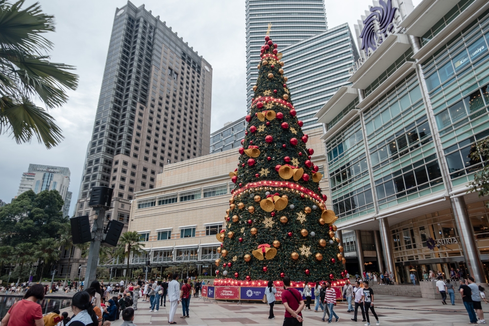 A giant Christmas tree adorned with ornaments stands tall outside Suria KLCC in Kuala Lumpur December 18, 2024, captivating visitors during the festive season. — Picture by Raymond Manuel