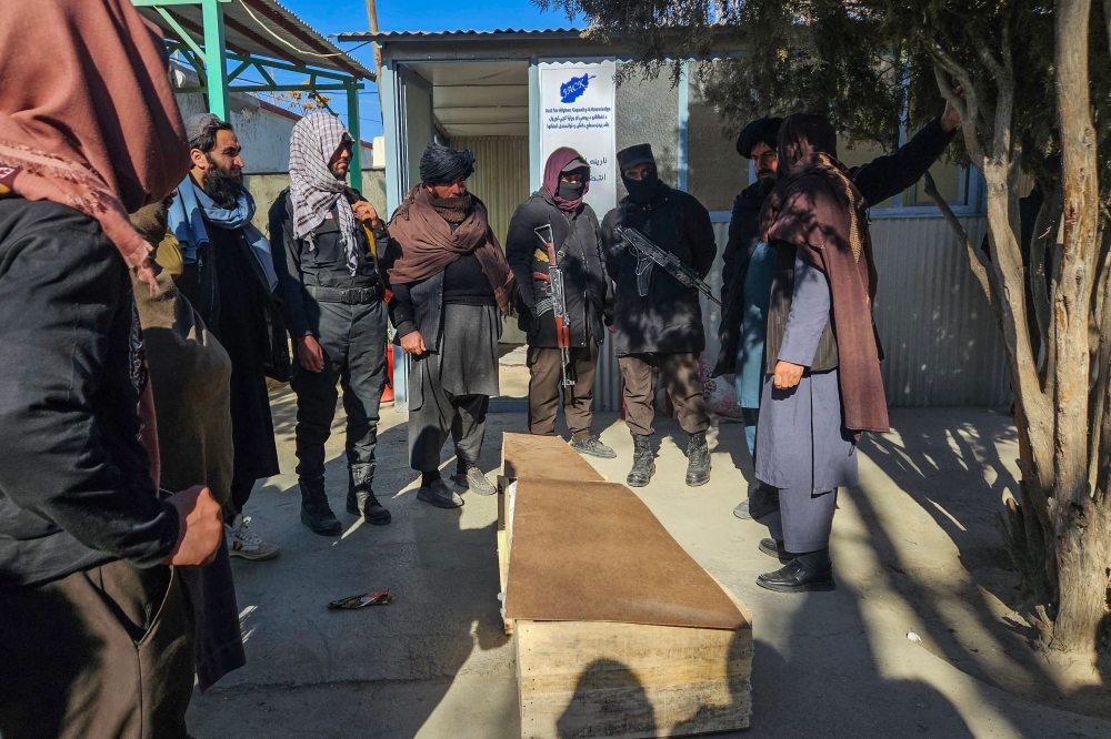 Taliban security personnel stand around a coffin of a passenger at a hospital after two bus accidents on the Kabul-Kandahar highway, in Ghazni on December 19, 2024. — AFP pic