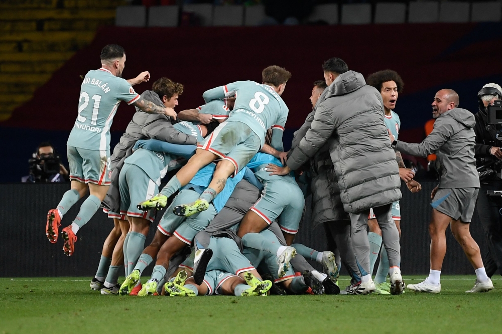Atletico Madrid's players celebrate after scoring their second goal during the Spanish league football match between FC Barcelona and Club Atletico de Madrid at the Estadi Olimpic Lluis Companys in Barcelona. — AFP