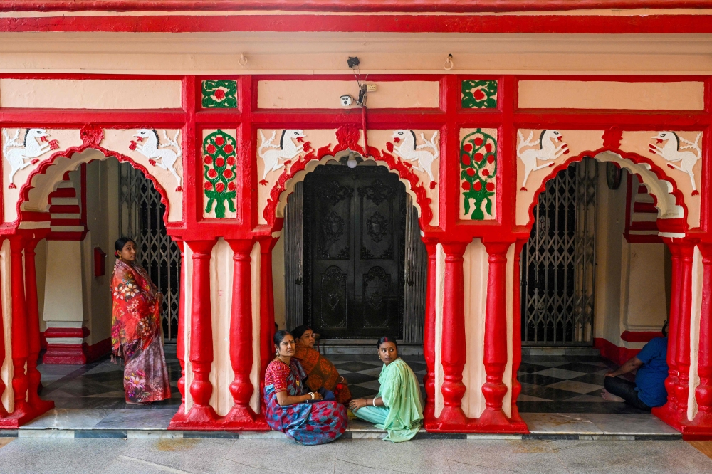 Hindu devotees sit at Dhakeshwari Temple in Dhaka. — AFP pic