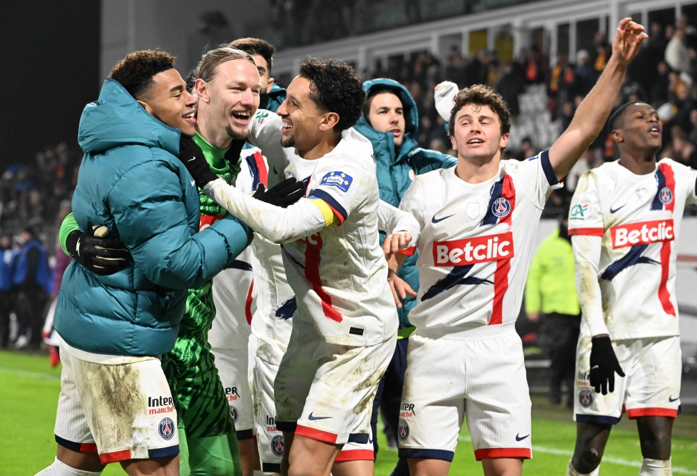 Paris Saint-Germain’s Marquinhos (center) celebrates with Paris Saint-Germain’s Russian goalkeeper Matvey Safonov (second from left) at the end of the French Cup round of 64 football match against Lens. — AFP