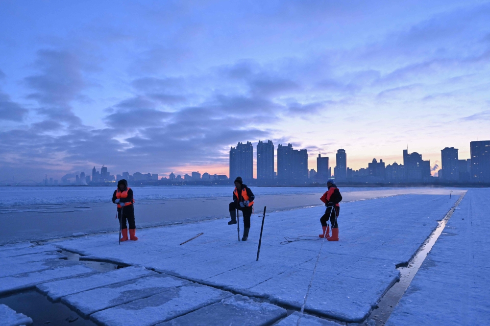 Workers harvest ice from the frozen Songhua river in preparation for the annual Harbin Ice and Snow World Festival December 17, 2024. — AFP pic