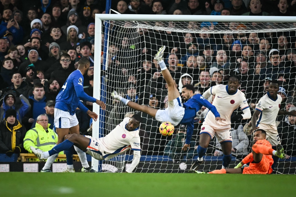Everton's Senegalese striker Iliman Ndiaye (centre) falls after colliding with teammate Beto (left) and Chelsea's defender Tosin Adarabioyo during the English Premier League football match between Everton and Chelsea at Goodison Park in Liverpool, north west England on December 22, 2024. — AFP pic