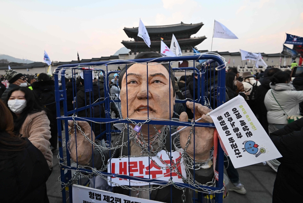 An effigy of South Korea's impeached President Yoon Suk Yeol  in a mock prison as protesters take part in a rally calling for Yoon's ouster on December 21. — AFP