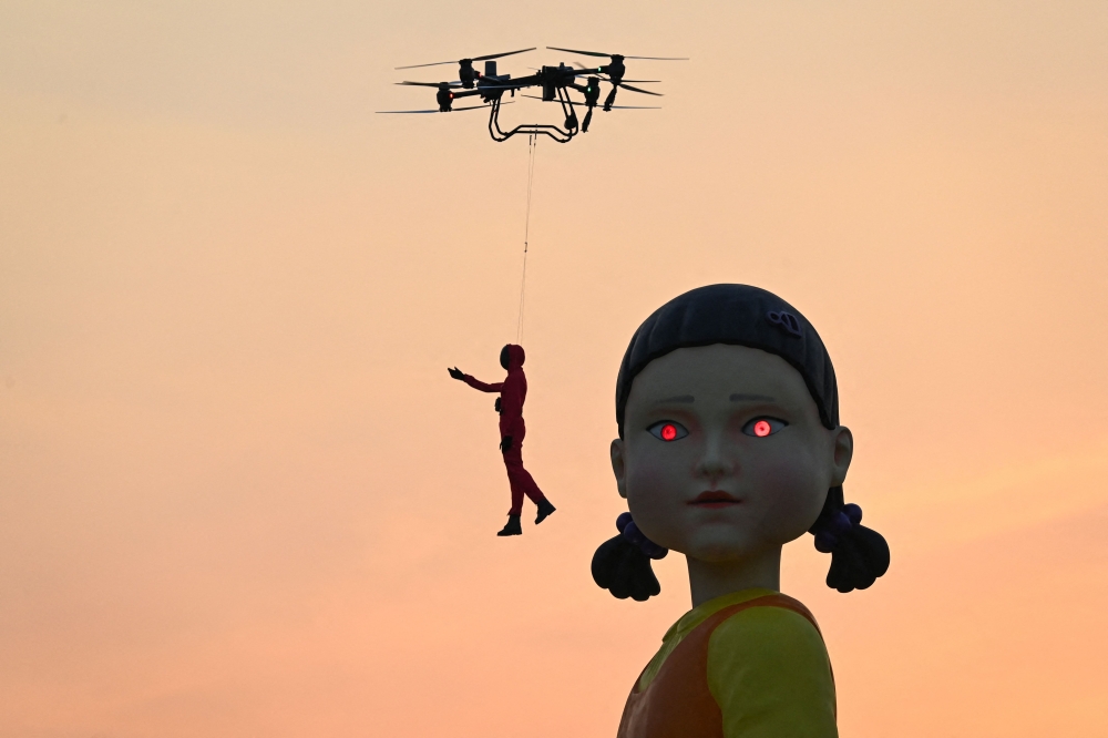 A 12 metre-tall statue of Young-hee, the iconic doll from Netflix’s South Korean TV series ‘Squid Game’, is seen on a barge in front of Wat Arun temple ahead of the launch of Season 2, in Bangkok on December 19, 2024. — AFP pic