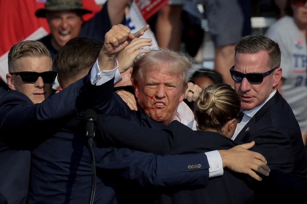 Republican presidential candidate and former US President Donald Trump is assisted by the Secret Service after gunfire rang out during a campaign rally at the Butler Farm Show in Butler, Pennsylvania, July 13, 2024. — Reuters pic 