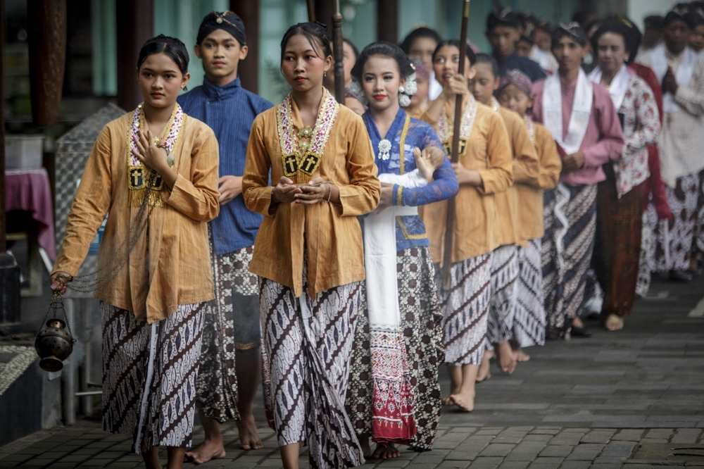 Catholics dressed in traditional Javanese clothes start the Christmas Mass procession at the Sacred Heart of Jesus Church in Ganjuran, Yogyakarta December 24, 2024. — AFP pic