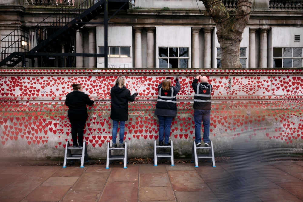 Volunteers hang lights on The National Covid Memorial Wall, dedicated to those who lost their lives to Covid-19, on the bank of the River Thames in London on December 20, 2024, ahead of the fifth anniversary of the pandemic. UK families of some 240,000 people who died from Covid-19 have hung festive lights on a London wall, a symbol of love, anger and pain ahead of another Christmas overshadowed by loss. — AFP pic 