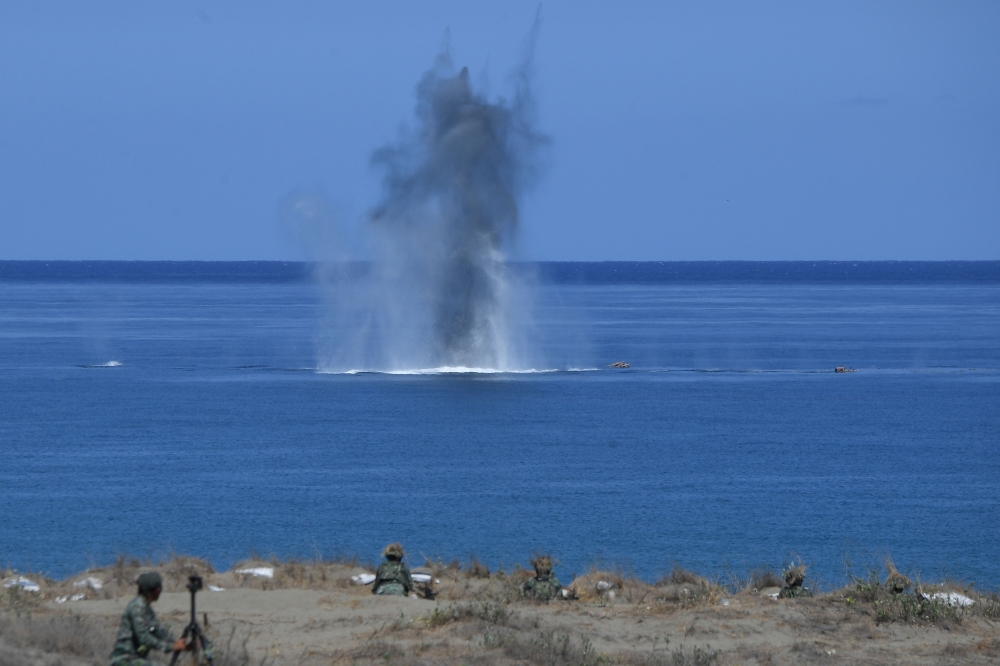 Philippine and US Marines watch as a projectile hits a target at sea during a live fire exercise against an imaginary ‘invasion’ force as part of the joint US-Philippines annual military Balikatan drills on a strip of sand dunes in Laoag on Luzon island’s north-west coast in this file photo taken on May 6, 2024. — AFP pic