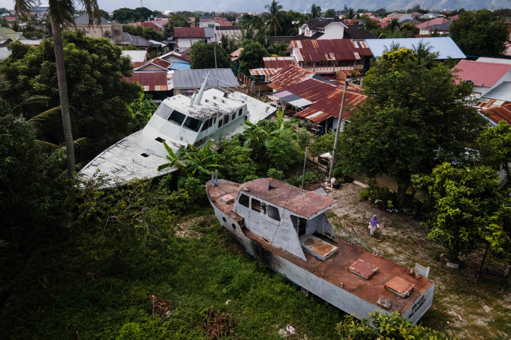 This aerial view shows two patrol boats washed ashore by the 2004 Indian Ocean tsunami and preserved at the community's in Banda Aceh on December 25, 2024. — AFP pic