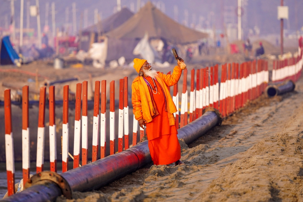 A sadhu or a Hindu holy man, takes his selfie near Sangam, the confluence of Ganges, Yamuna and mythical Saraswati rivers, ahead of the Maha Kumbh Mela festival in Prayagraj on December 22, 2024. — AFP pic
