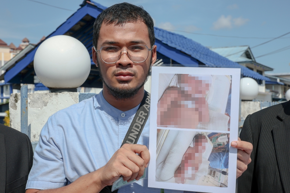 Muhammad Syarifuddin Manan, 24, shows the police report and photos of his baby daughter’s condition, who is said to have fallen from the baby cot when he was met at the Kuala Terengganu District Police Headquarters, December 26, 2024. — Bernama pic 