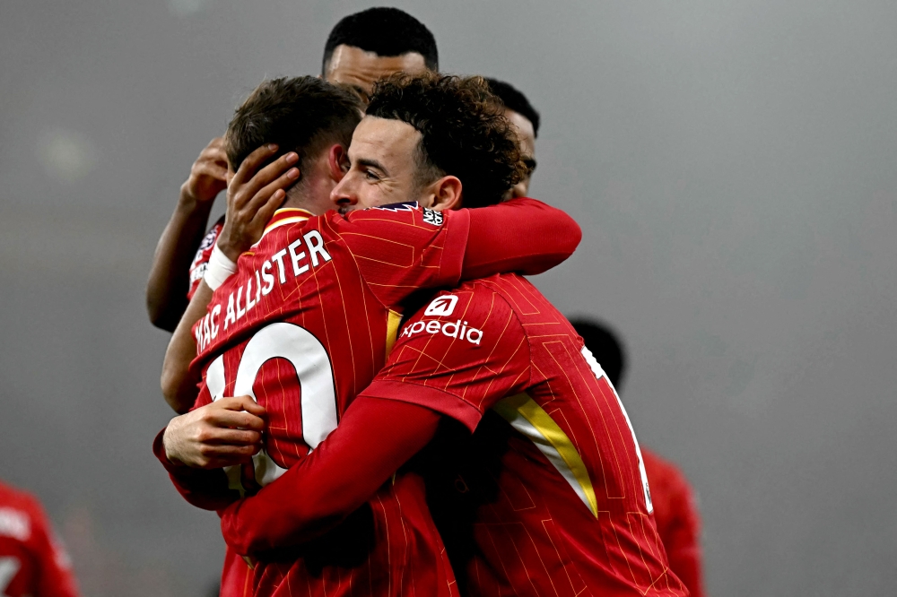  Liverpool’s Curtis Jones (right) hugs midfielder Alexis Mac Allister (left) after scoring the team ’ s second goal. — AFP