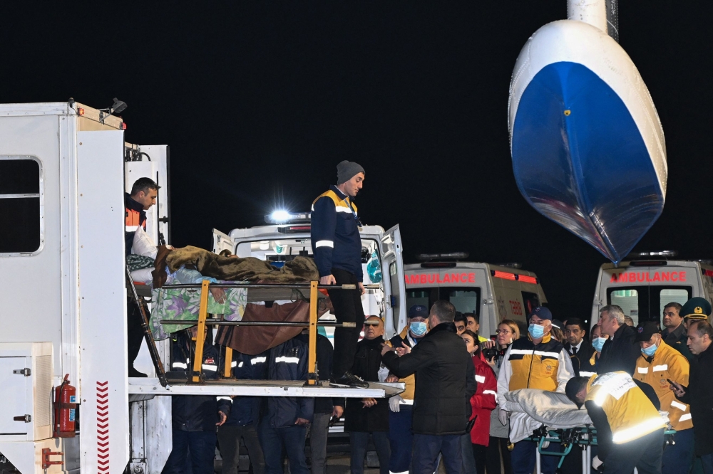 Airport ground staff amd medics assist Azerbaijani citizens, who survived the crash of the Azerbaijan Airlines’ Embraer 190 passenger jet near the western Kazakh city of Aktau. — AFP